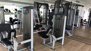 A gym with various exercise machines, including a stair climber and weight machines. - Paradise at Shangrila, Beachfront (Puerto Vallarta)