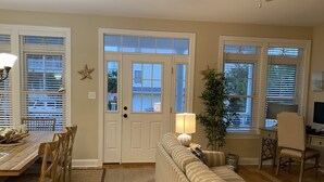 A living room with a wooden dining table, striped sofa, and a desk with a computer. - Great Location - Close to Beach, Boardwalk, Asbury Shops and Cafes! (Ocean City)