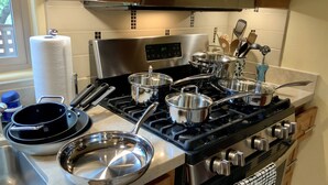 A kitchen with a stove, pots, pans, and a microwave. - Unique, Custom Built Studio for your Private Peaceful Retreat (Green Valley)