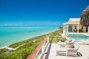 Une propriété située en bord de mer, dotée d’une piscine, d’un espace extérieur aménagé et offrant une vue sur l’océan.