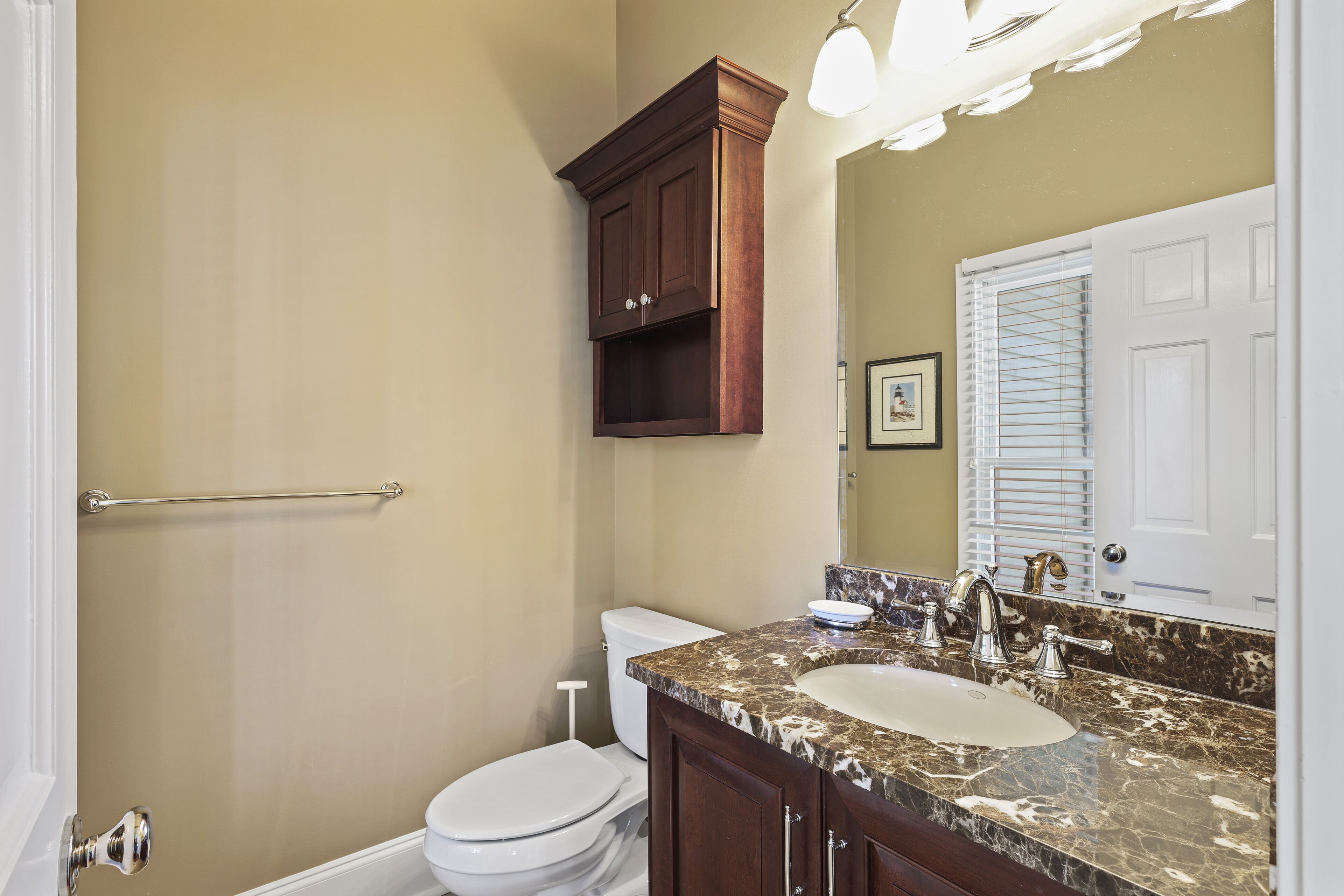 A bathroom with a toilet, sink, and vanity.