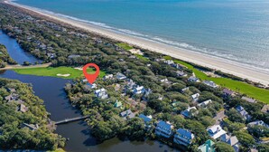 Vista aérea de una zona residencial costera con casas, una playa y un río.