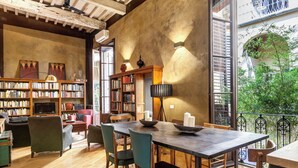 A cozy library with bookshelves, a dining table, and chairs. - Historical apartment in the heart of Florence with exclusive terrace (Firenze)