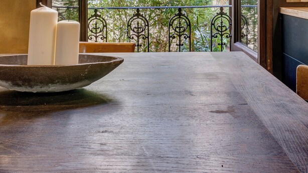 A view from a balcony with a wooden table, two white candles, and a metal railing. - Historical apartment in the heart of Florence with exclusive terrace (Firenze)