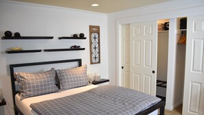 A bedroom with a bed, bedside tables, a wardrobe, and a door leading to a closet.