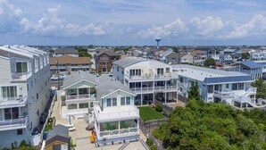 A coastal residential area with multiple two-story houses featuring balconies and large windows. - Oceanfront! Fenced in back yard! Pet Friendly! Come visit anytime👍 (Brigantine)