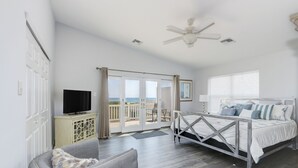 A bedroom with a bed, a television, a chair, and a balcony with a view. - Oceanfront! Fenced in back yard! Pet Friendly! Come visit anytime👍 (Brigantine)
