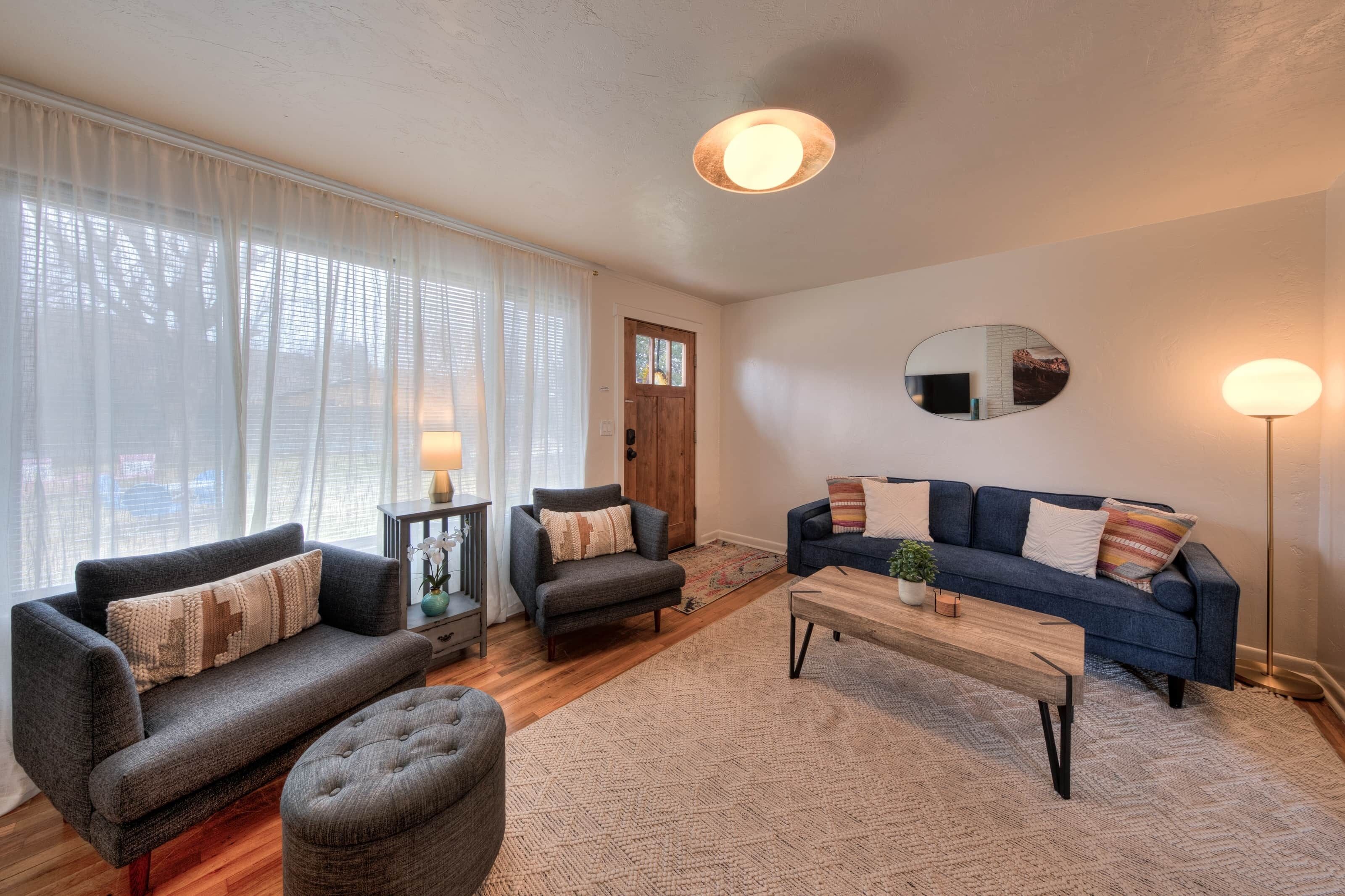 Ein Wohnzimmer mit einer Couch, Sesseln, einem Couchtisch und einem Teppich.