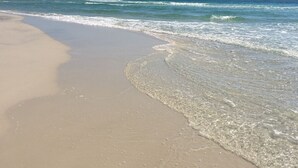 Una spiaggia con acque cristalline e una riva sabbiosa.