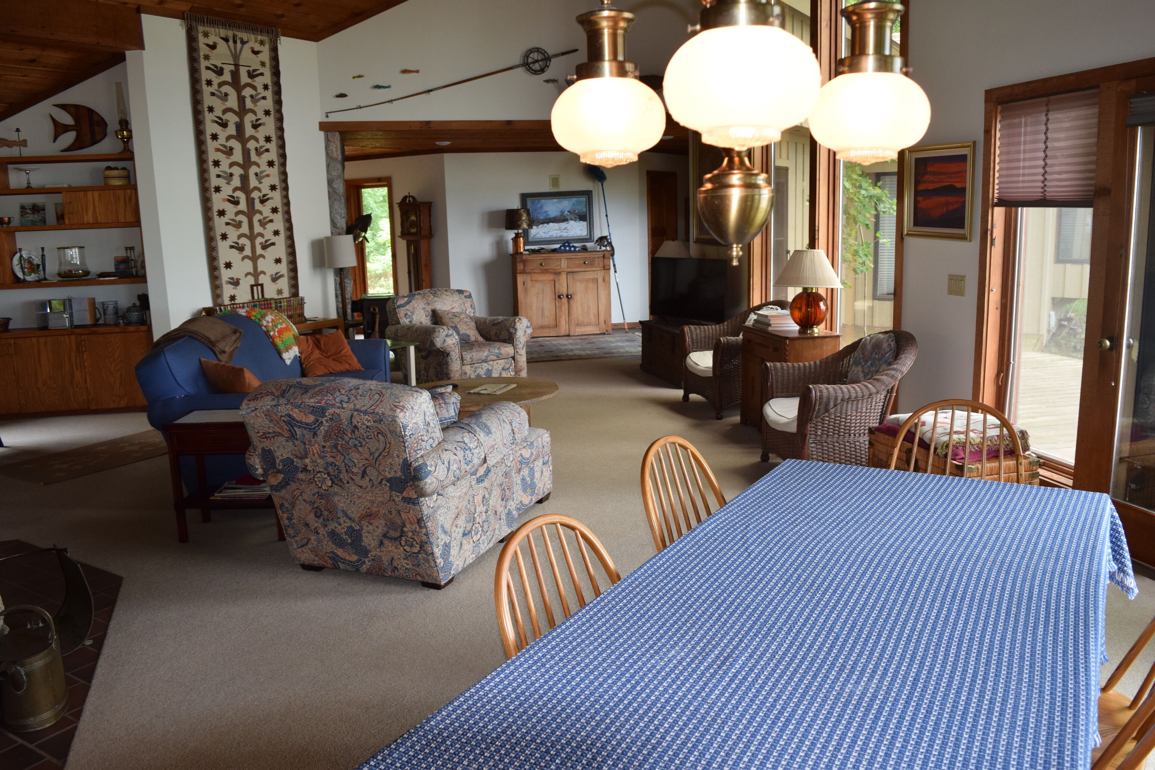 Una sala de estar acogedora con una mesa azul, sofás con diseños y sillas de madera.