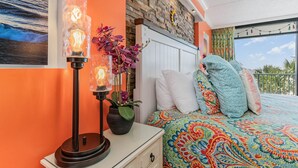 Un dormitorio con una cama, una mesita de noche, una lámpara y un cuadro en la pared.