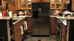 A modern kitchen with wooden cabinets, a stainless steel refrigerator, and granite countertops. - 3 Bedroom Condo,  Great Location for Ski Families to Super Bee Lift (Copper Mountain)