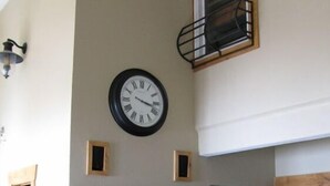 A living room with a large wall clock, a flat-screen TV, and built-in wooden cabinets. - 3 Bedroom Condo,  Great Location for Ski Families to Super Bee Lift (Copper Mountain)