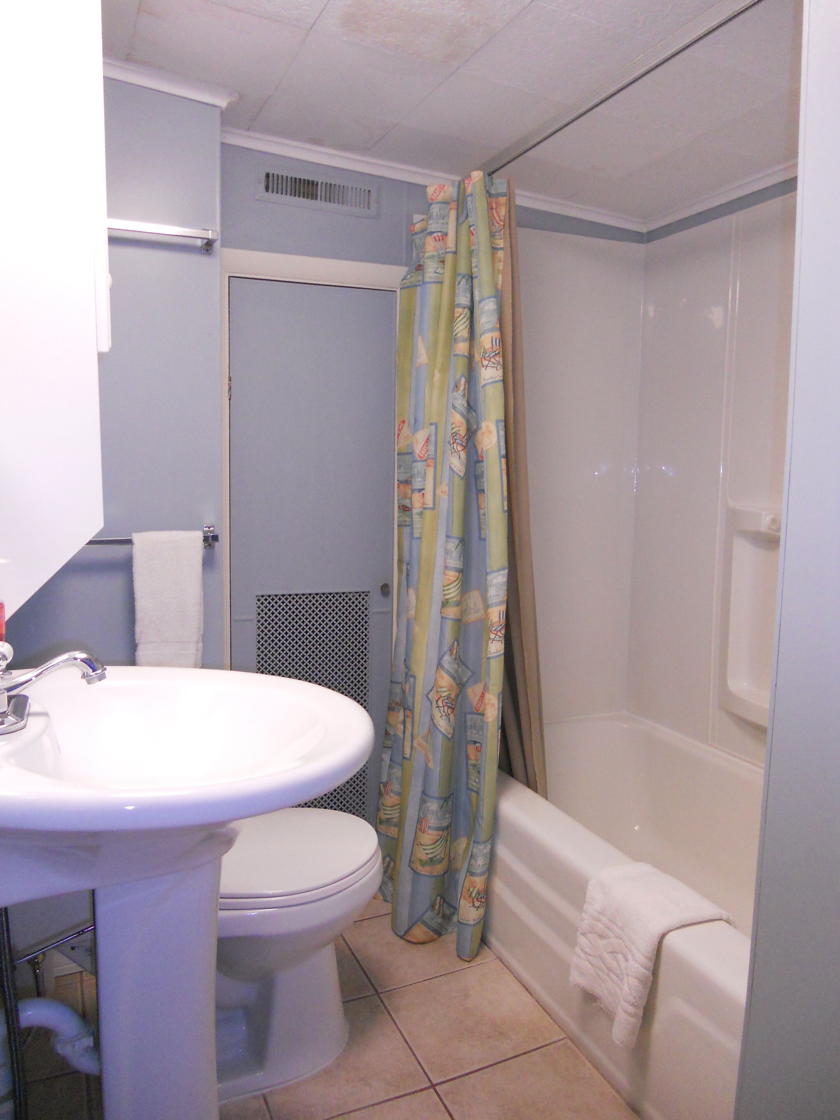 A bathroom with a toilet, sink, and bathtub.