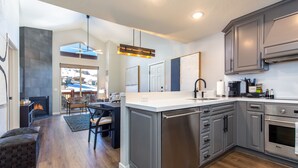 A modern kitchen with grey cabinets, stainless steel appliances, and a central island. - Ski In/Out 2BD Top floor W/Amazing Views (Park City)