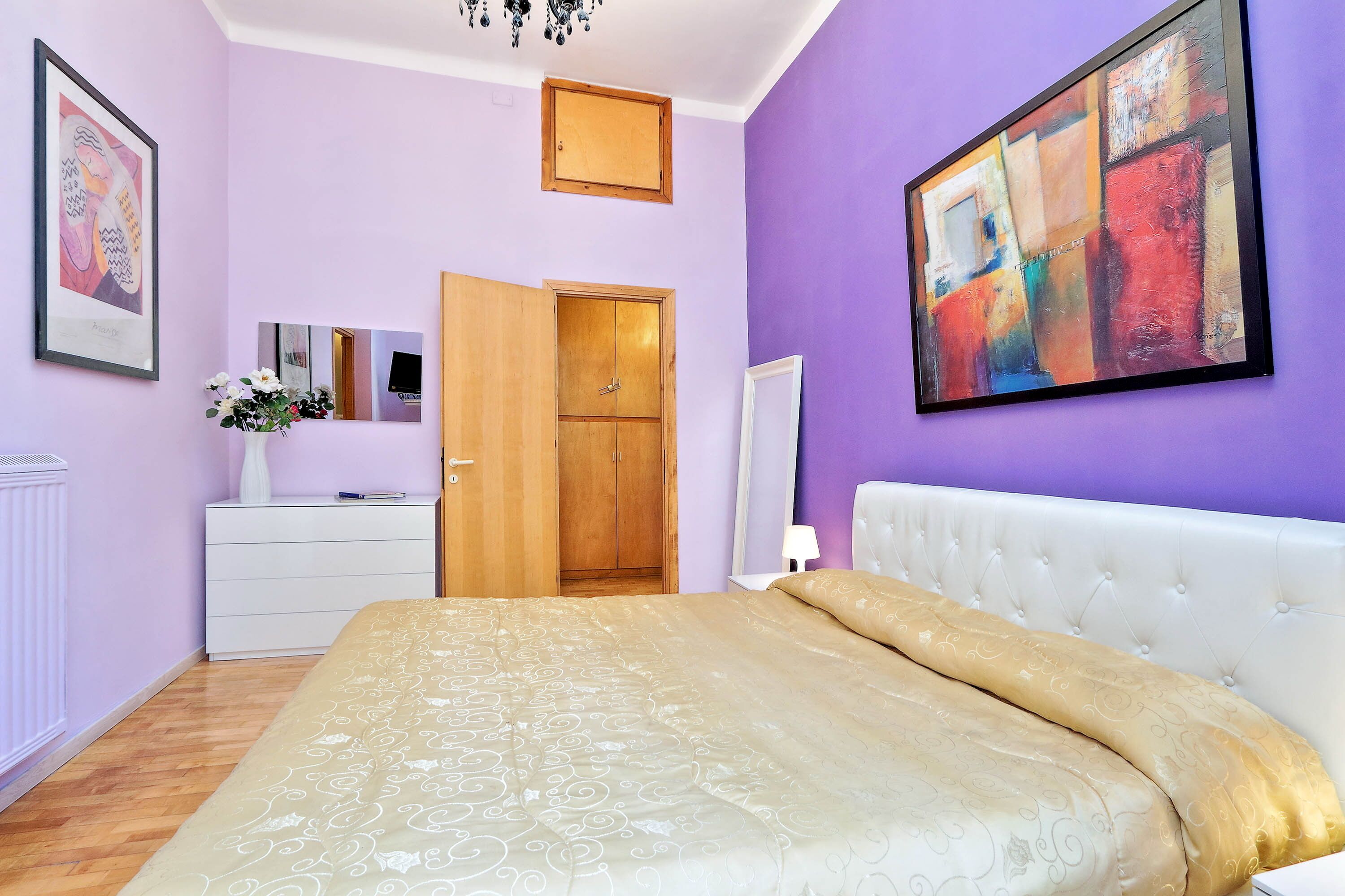 A bedroom with a bed, dresser, and wardrobe.