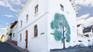 A white building with a mural of a tree on its side.