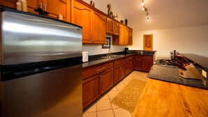 A modern kitchen with wooden cabinets, stainless steel appliances, and a granite countertop. - Family Friendly Home, with a Man Cave! (Keaau)