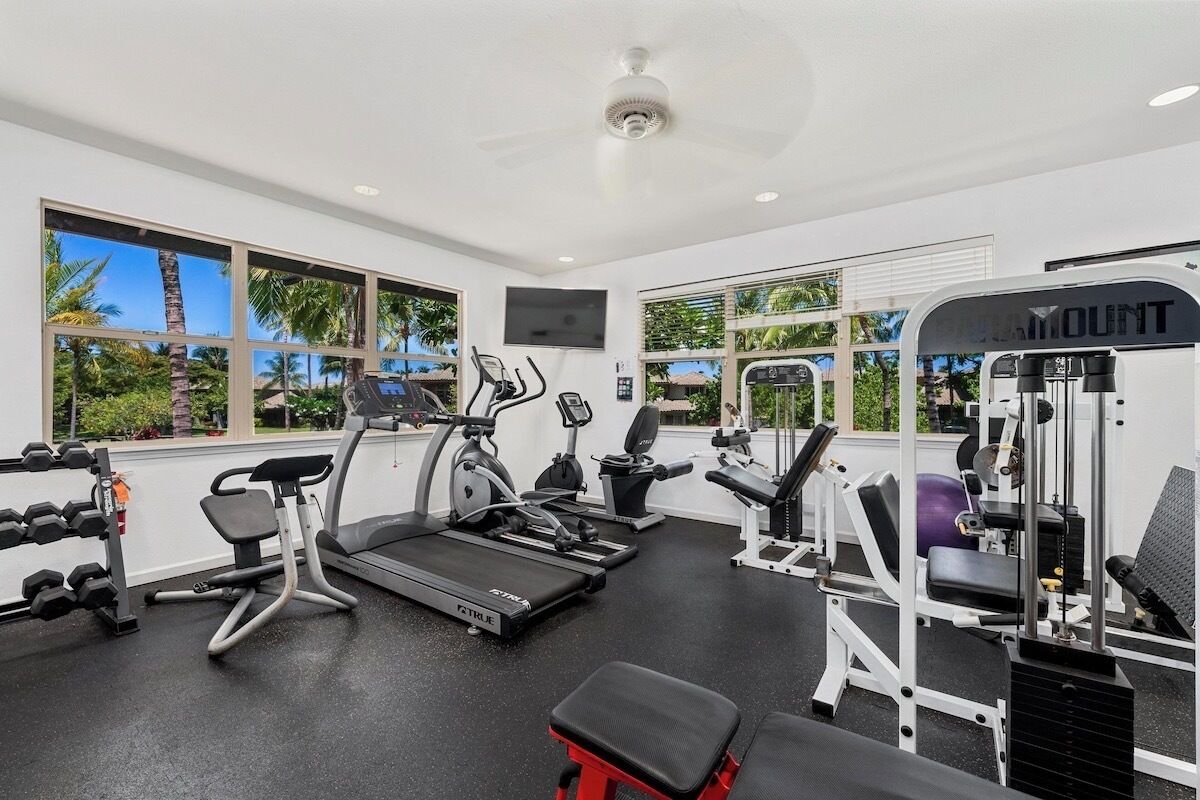 A gym with treadmills, elliptical machines, and weightlifting equipment.