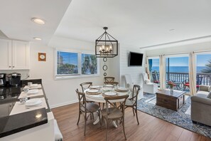 A modern kitchen with a dining area, a living room with a view, and a balcony. - Oceanfront Views, Community Pool, Great Resort Location! (Isle Of Palms)