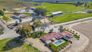 A large estate with multiple buildings, a swimming pool, and expansive green fields. - Luxury Adobe in Wine Country w/ Pool, Hot Tub & Ping-Pong, 10 min from downtown (Paso Robles)