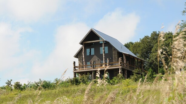 Eine rustikale Holzhütte mit Balkon und geneigtem Dach.