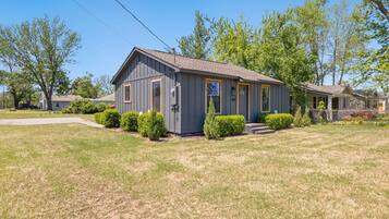 A single-story house with a gray exterior, a front porch, and a well-maintained lawn.