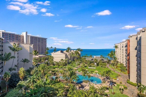 Ein Resort mit Pool, Palmen und Meerblick.