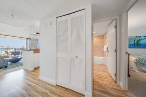 Ein modernes Hotelzimmer mit einer großen Schiebetür, Meerblick, einem Balkon mit Sitzgelegenheit und einem Badezimmer mit einer Badewanne.