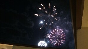 Un balcon offrant une vue sur les feux d’artifice dans le ciel nocturne.