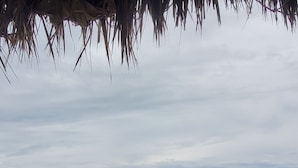 Una playa con olas y cielo nublado.