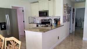 Una cocina con una isla central, electrodomésticos de acero inoxidable y armarios de color claro.