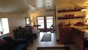 Una cocina compacta con comedor, sofá y ventana.