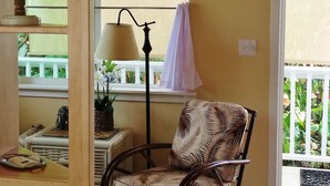 A cozy room with a wicker chair, a globe on a shelf, a lamp, and a window with curtains.