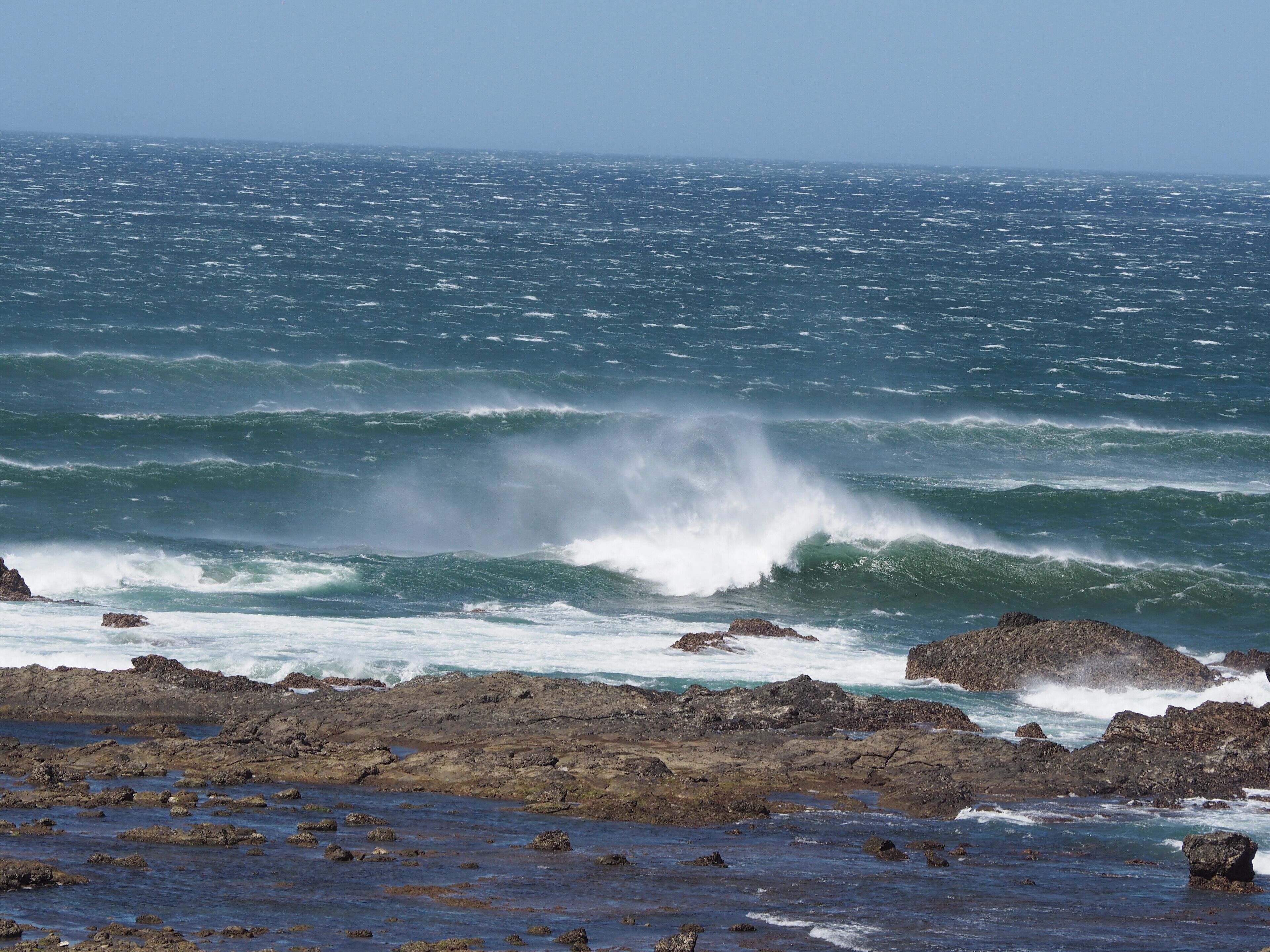 A rocky shoreline with waves crashing against the rocks.