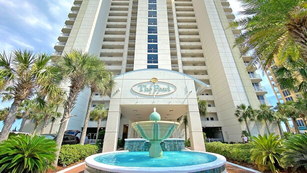 A high-rise hotel with a central fountain, palm trees, and a clear sky. - Relaxin' at The Pearl.
Ocean front condo with direct beach access. (Navarre)