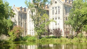 A historic stone building with a large pond in front, surrounded by trees and greenery. - Country and  beach, the best of both worlds. (Famalicão da Nazaré)