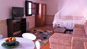 A bedroom with a bed, a TV, a desk, and a chair. - Country and  beach, the best of both worlds. (Famalicão da Nazaré)