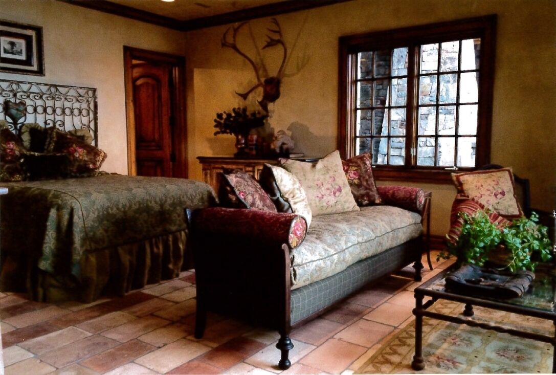 A cozy room with a sofa, a chair, a table, and a window with a view.
