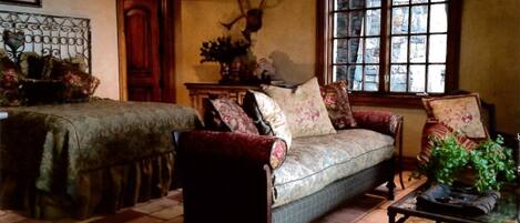 A cozy room with a sofa, a chair, a table, and a window with a view.