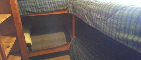 A bunk bed with a wooden frame and blue bedding.