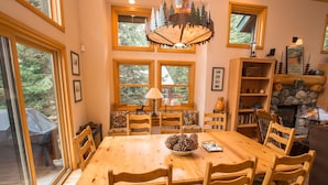 A wooden dining table with chairs, a chandelier, and a fireplace. - Mountain Luxury Retreat for families & friends, new hot tub, 4 bedroom, 2.5 bath (Truckee)