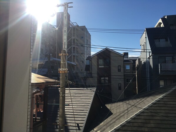 Un edificio residencial con varios pisos, techo inclinado y líneas eléctricas visibles.