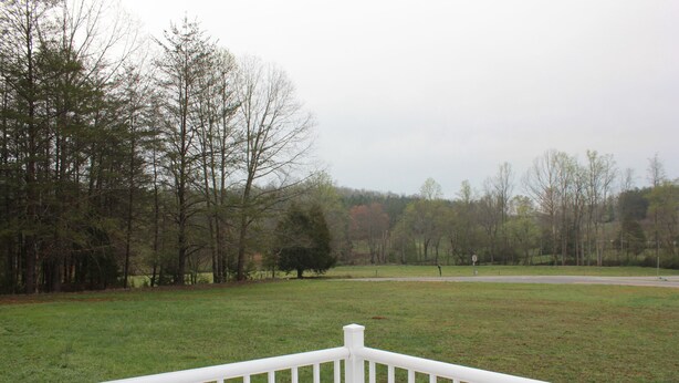 A grassy field with a white fence in the foreground and trees in the background. - Rider's Rest #1: Within 2 Miles Of Tryon International Equestrian Center (Rutherfordton)