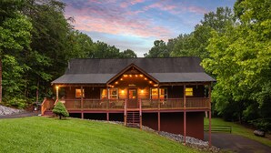 A lodge with a wooden exterior, a covered deck, and a well-maintained lawn. - Amazing & beautiful with huge yard for kids to play with outdoor games, fire pit (Sevierville)