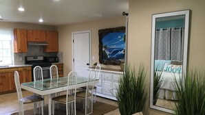 Una cocina moderna con armarios de madera, una mesa de comedor de vidrio y sillas blancas.