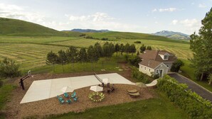 Una casa con un amplio patio, mobiliario exterior y vistas del paisaje circundante.