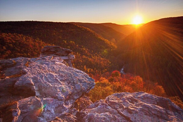 A mountainous landscape with a prominent rock formation in the foreground and a sunset in the background. - Davis, WV 2BR full kitchen NR Stumptown Ales (Davis)