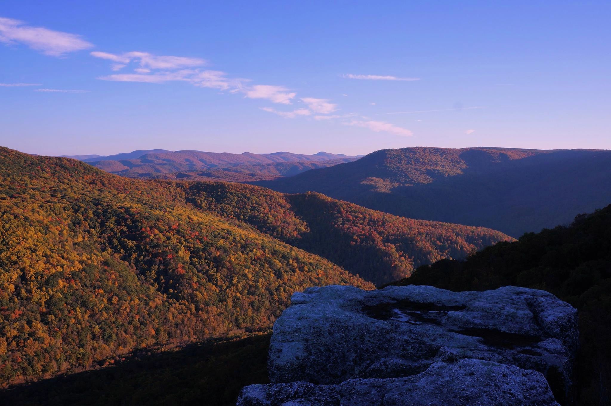 A mountainous landscape with autumn foliage and a prominent rock formation.