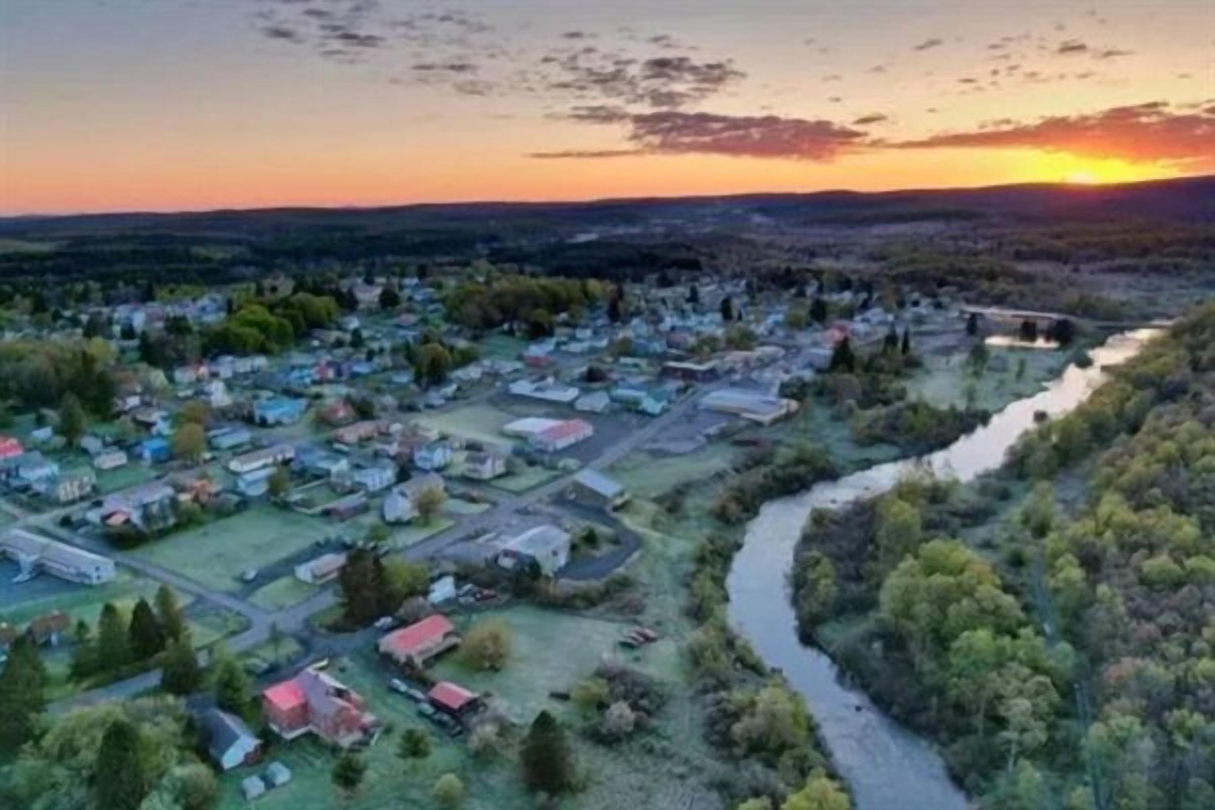 A river flowing through a town with houses and buildings along the riverbanks.